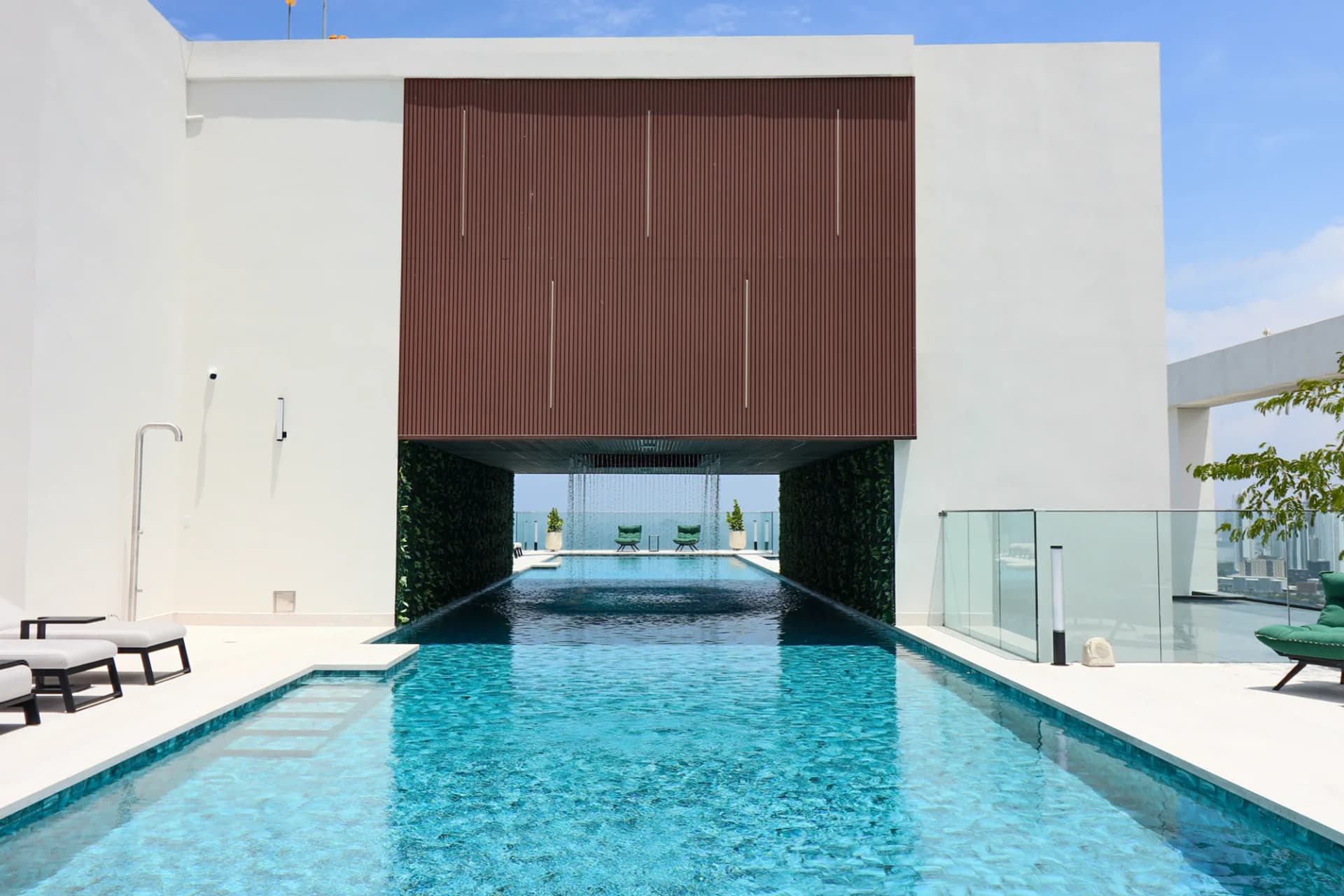 Piscina con cascada y áreas de descanso en THE IVY